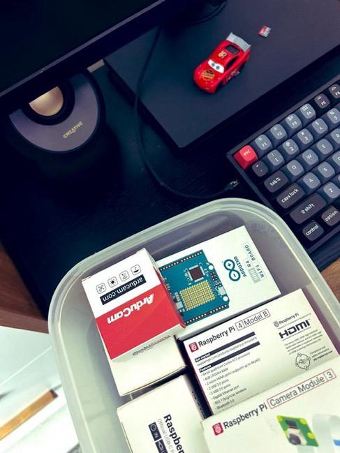 A box of boxed boards — Arduino, ArduCam, Raspberry Pi 4 and a Pi Camera Module 3 — beside a keyboard