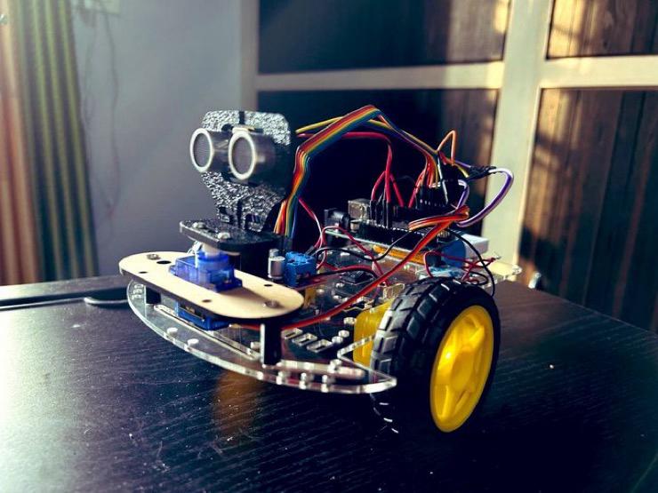 An Arduino robotic car with an ultrasonic sensor, servo and yellow wheels