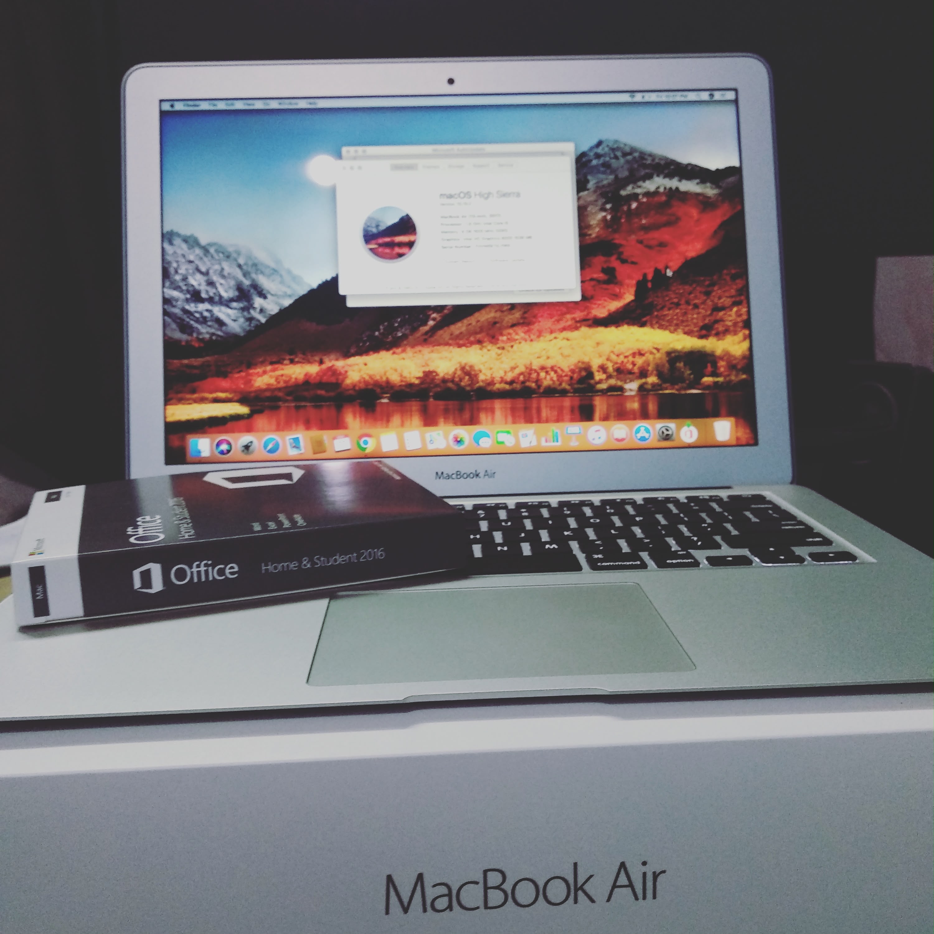 A MacBook Air running macOS High Sierra, sitting on its own box beside a boxed copy of Office 2016